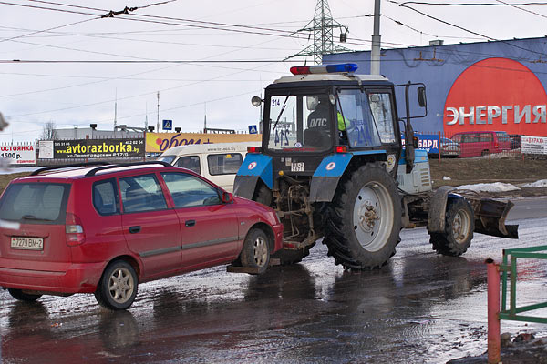 Трактор-эвакуатор буксирует автомобиль на штрафстоянку в Витебске. Фото Сергея Серебро