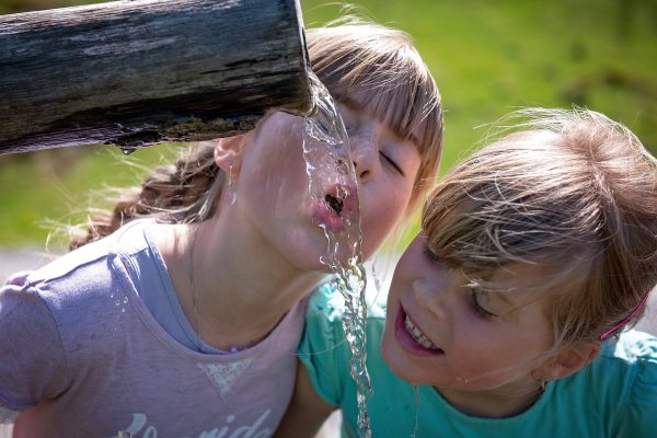 Дети пьют воду, вода течет из трубы. Фото pixabay.com