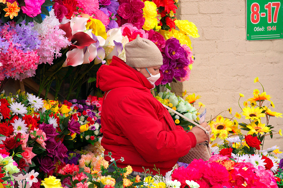Продавец искусственных цветов в медицинской маске на рынке. Фото Сергея Серебро