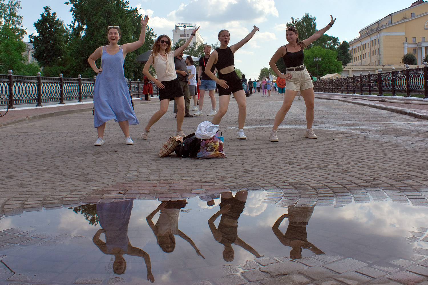 Отражение танцующих девушек в луже. Фото Сергея Серебро